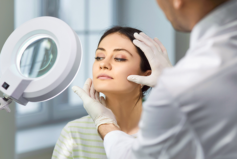 Doctor evaluating woman’s facial structure during facial balancing consultation at Becker Plastic Surgery in Philadelphia