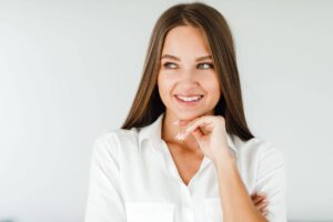 Confident young woman smiling with natural-looking nose results after successful rhinoplasty procedure.