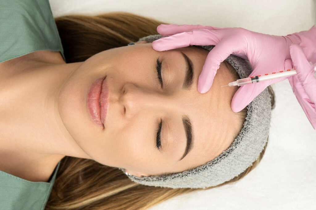 Young woman receiving a Botox treatment on her forehead.