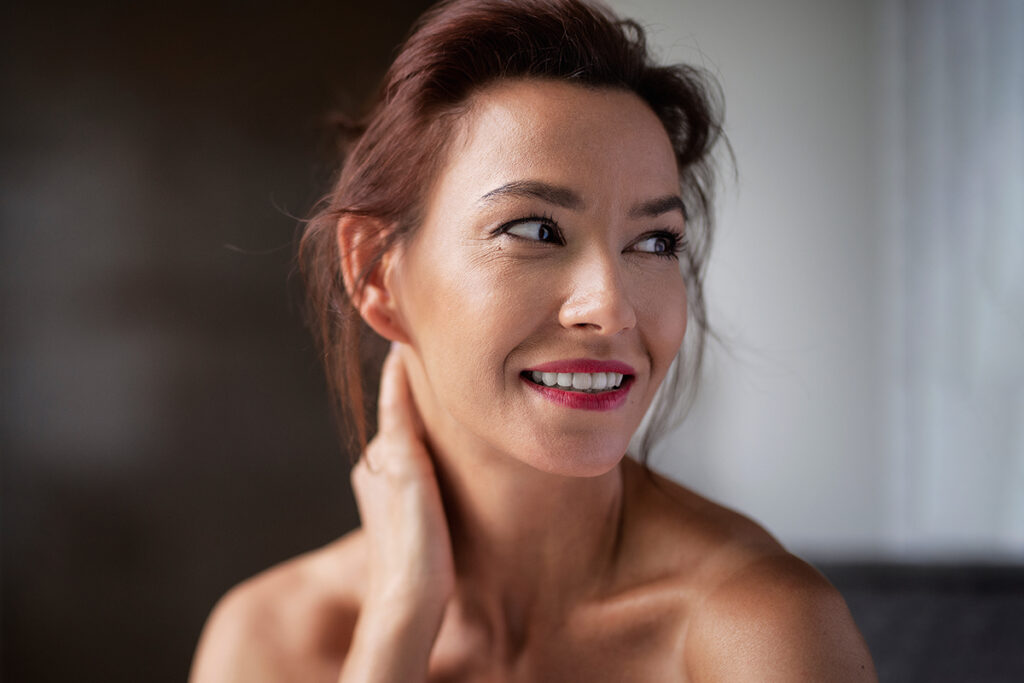 Smiling woman with smooth skin and subtle expression showing natural results after preventive Botox treatment