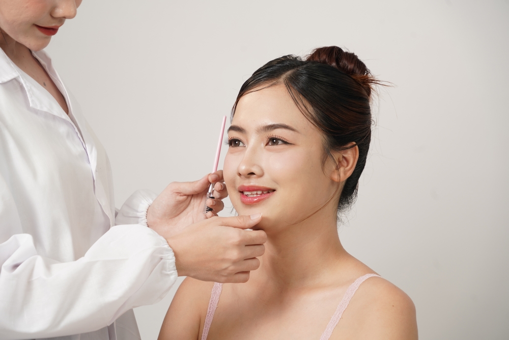Surgeon marking a woman’s face for rhinoplasty, reflecting ethnic rhinoplasty’s focus on cultural and aesthetic balance.