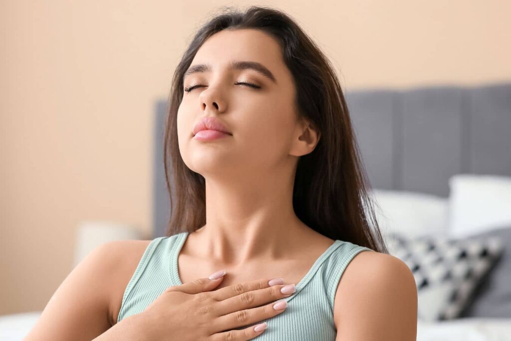 Woman practicing deep breathing to relieve nasal obstruction after rhinoplasty, highlighting functional airway restoration benefits