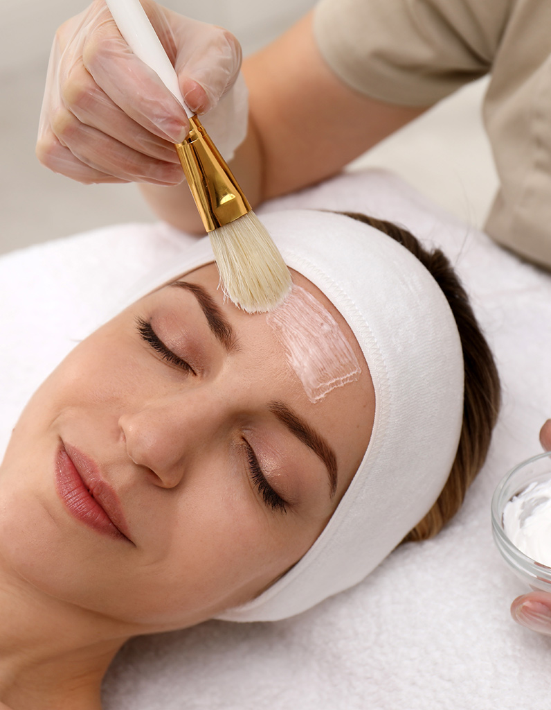 Chemical peel solution applied to forehead during facial treatment.