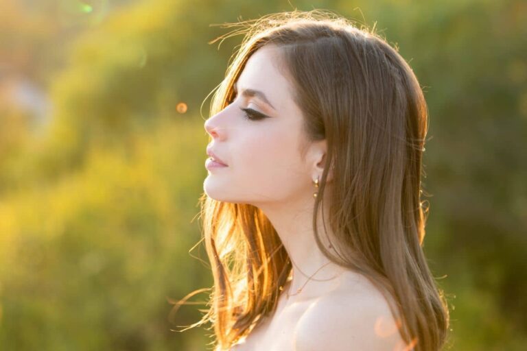 Side profile of woman in natural light highlighting nasal structure, suitable for functional vs cosmetic rhinoplasty article.