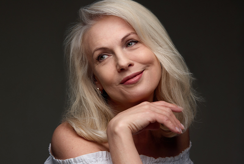 Confident mature woman with smooth skin reflecting natural-looking facelift results in New Jersey and Philadelphia.