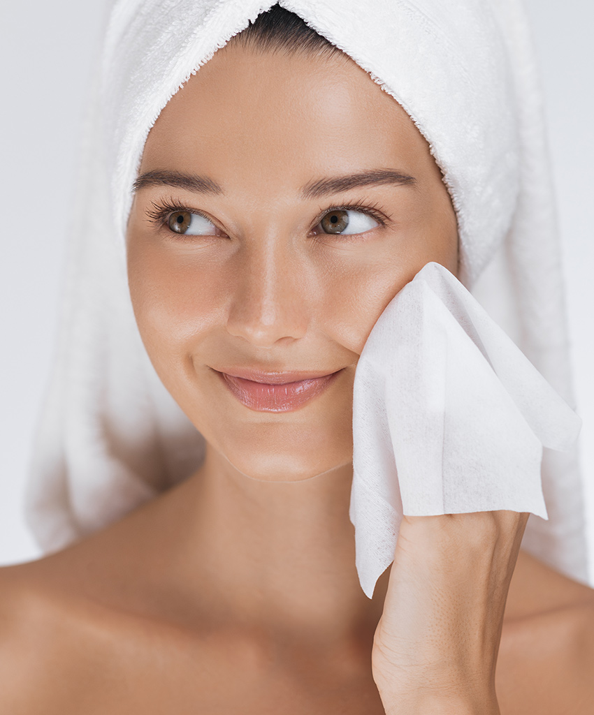 Woman cleansing face, representing Glytone skincare for clearer, healthier skin.