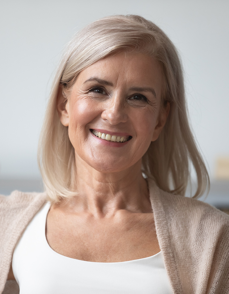 Smiling woman with restored facial volume representing Radiesse dermal filler results.
