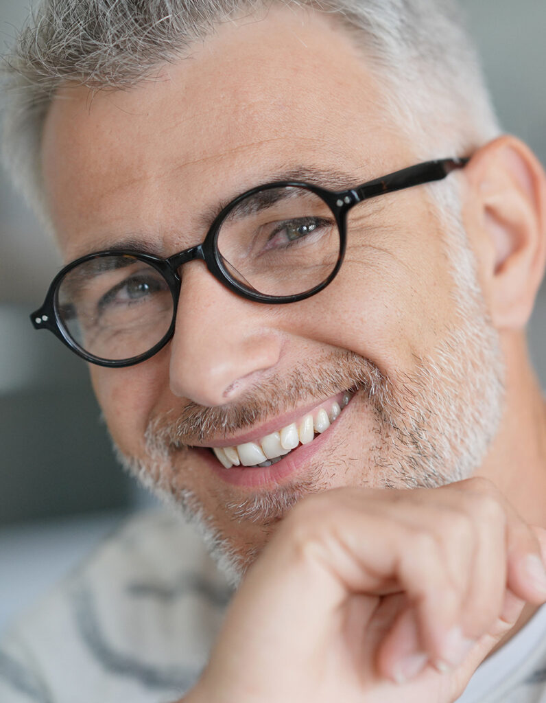 Smiling man representing a good candidate for reconstructive surgery, highlighting overall health and positive outcomes.