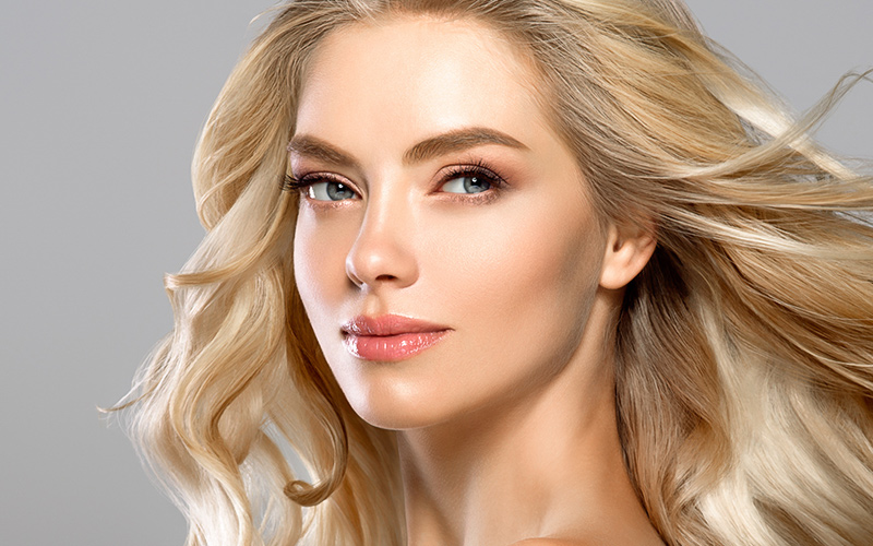 Blonde woman with refined facial features and balanced nose, representing rhinoplasty results in Philadelphia.