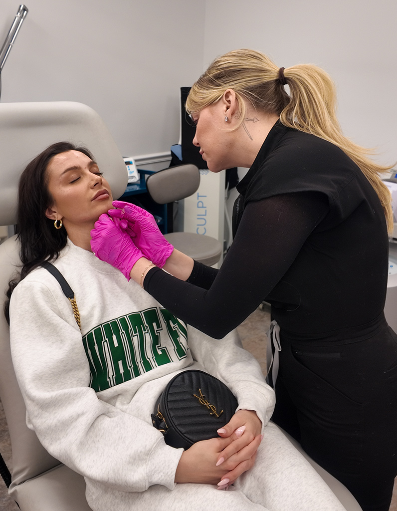 Provider performing chemical peel treatment on patient’s chin to improve skin tone and texture in clinic.