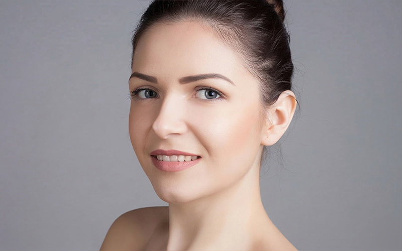 Woman with smooth nasal bridge illustrating rhinoplasty outcomes for saddle nose deformity treatment in Philadelphia.