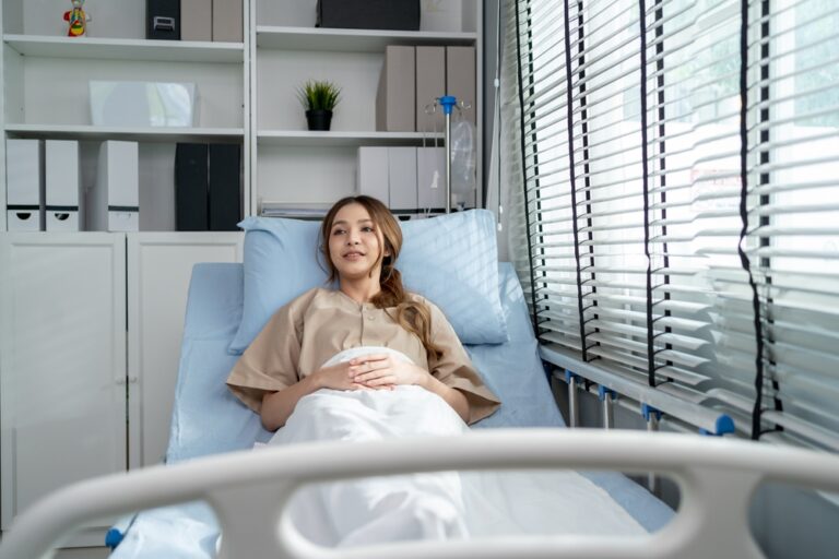 Woman resting in bed during the first week of labiaplasty recovery and early healing